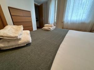 ein Hotelzimmer mit einem großen Bett und zwei Stühlen in der Unterkunft Oktheway Santander Street 5 in A Coruña
