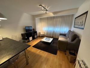 ein Wohnzimmer mit Sofa und Tisch in der Unterkunft Oktheway Santander Street 5 in A Coruña