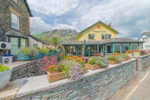 un edificio con flores en una pared de piedra en Meadowdore Stay B&B, en Coniston