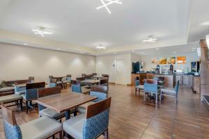 a dining room with tables and chairs and a kitchen at Comfort Suites East in Knoxville