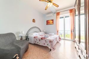 Un dormitorio con una cama y un sofá y una ventana. en Villa Grace Amalfi seaview, en Amalfi