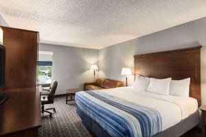 a hotel room with a bed and a desk at AmericInn by Wyndham Madison West in Madison