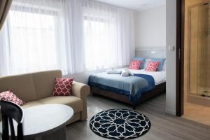 チェホチネクにあるVilla Andalucia SPA & Leisureのベッドルーム1室(ベッド1台、ソファ、椅子付)