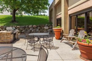 a patio with tables and chairs in front of a building at AmericInn by Wyndham Madison West in Madison