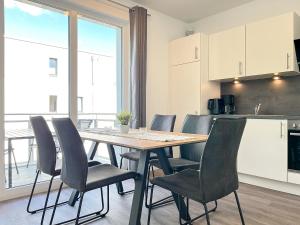 kuchnia i jadalnia ze stołem i krzesłami w obiekcie Weiße Villen Wohnung 20 w mieście Boltenhagen