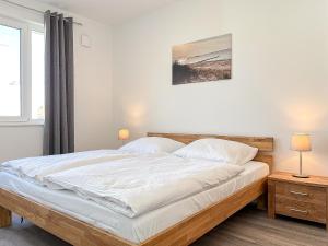 sypialnia z dużym białym łóżkiem i oknem w obiekcie Weiße Villen Wohnung 20 w mieście Boltenhagen