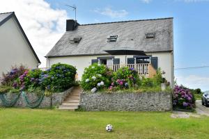 a house with a yard with a soccer ball in the grass at Maison Grand Large - A 800 m de la plage in Saint-Cast-le-Guildo