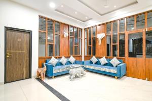a living room with a blue couch and a dog at FabHotel Suraj Kunj in Indore