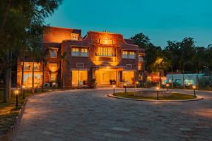 ein großes Backsteingebäude mit Lichtern davor in der Unterkunft Tree Of Life Bhadrajun House, Jodhpur in Jodhpur