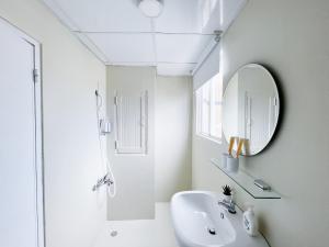 a white bathroom with a sink and a mirror at See U Apartment in Tainan
