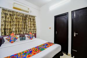 una camera da letto con un grande letto con cuscini colorati di FabExpress Moon Residency a Calcutta