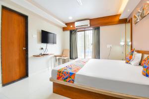 Postel nebo postele na pokoji v ubytování FabHotel Prime Rajmudra - Nr Butterfly Park - Hinjawadi + 21 fotografií