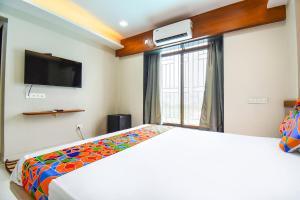 Postel nebo postele na pokoji v ubytování FabHotel Prime Rajmudra - Nr Butterfly Park - Hinjawadi