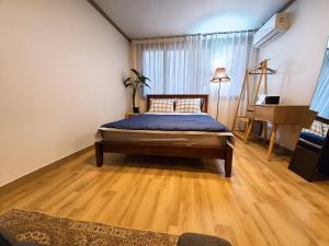 a bedroom with a bed and a wooden floor at 3 Rooms for rent near Mapo-gu Office Station, Mapo-gu, Seoul in Seoul