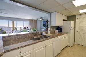 a kitchen with a sink and a refrigerator at Long Beach Resort 2-901 - Sunset Beach Club in Panama City Beach