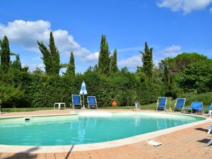 a swimming pool with blue chairs and a group at Restful Farmhouse near Forest in Vinci with Pool in Vinci