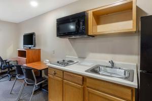 a small kitchen with a sink and a microwave at WoodSpring Suites Raleigh Garner in Edmondson
