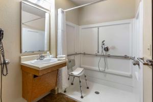 WoodSpring Suites Raleigh Garner في Edmondson: حمام مع حوض ودش