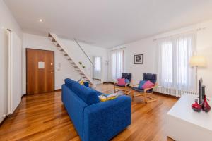 a living room with a blue couch and chairs at Corte Nova in Venice