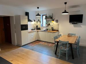 cocina con mesa de madera y comedor en Borcsa Pihenőház en Mezőkövesd