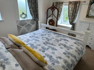 a bedroom with a bed with a blue and white blanket at Bay View Cottage in St Austell