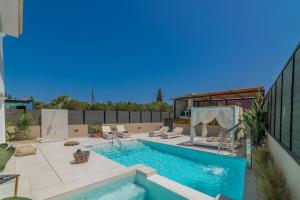 een zwembad in een achtertuin met een huis bij Fratelli Villa, with Heated Pool & Jacuzzi, By ThinkVilla in Áyios Kírikos