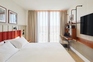 a hotel room with a bed and a television at Via Sants Hotel Barcelona, Tapestry Collection By Hilton in Barcelona