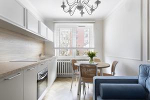 a kitchen and dining room with a table and chairs at Elite Apartments Center Superior in Gdańsk