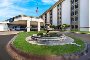 a fountain in the grass in front of a building at Clarion Hotel San Angelo near Convention Center in San Angelo