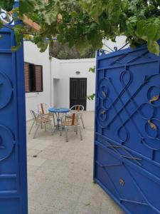 a blue gate with chairs and a table at Ioanna Residence Kattavia in Kattavía