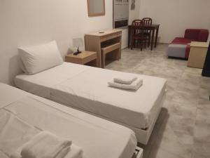 a hotel room with two beds and a desk at Ioanna Residence Kattavia in Kattavía