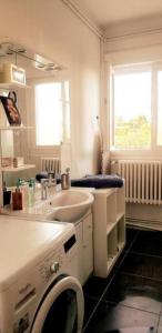 y baño blanco con lavabo y lavadora. en Maison familiale - ménage, serviettes, draps inclus, en Gaillac