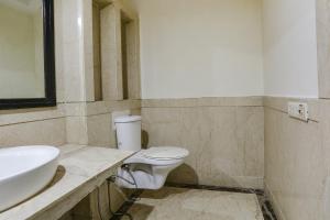 uma casa de banho com um WC branco e um lavatório. em FabHotel Blue Moon Home Stay em Nova Deli