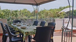 een tafel met stoelen en een parasol op een patio bij Taormina 5 stars - Villa 5 minutes from the beach in Riposto