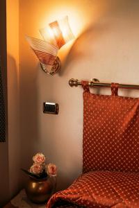 um quarto com uma cama com um candeeiro e flores em Hotel Liberty em Spresiano