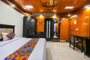 Schlafzimmer mit einem Bett, einem Tisch und einer Tür in der Unterkunft FabHotel Blue Moon Home Stay in Neu-Delhi