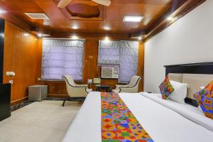 a bedroom with a bed and a desk and chairs at FabHotel Blue Moon Home Stay in New Delhi