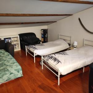 um quarto com duas camas e uma cadeira em Maison d'hôtes naturiste em Ville-sur-Yron