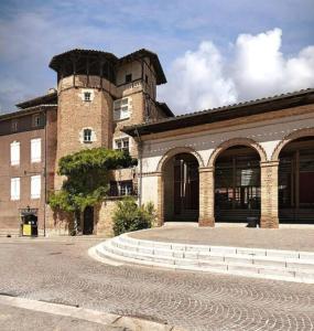 un gran edificio de ladrillo con una torre encima en Maison familiale - ménage, serviettes, draps inclus, en Gaillac