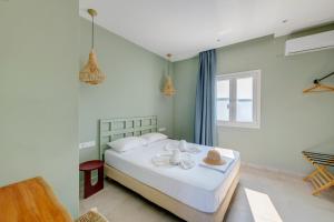 a bedroom with a bed with white sheets and a window at Armenaki in Azolimnos Syros +152 photos
