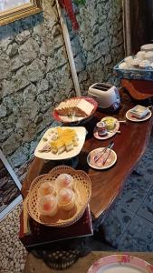 una mesa de madera con platos de comida. en ครูไสวโฮมสเตย์, 