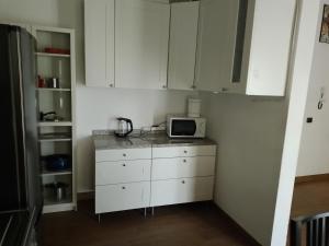 Una cocina con gabinetes blancos y un microondas en una encimera. en Casa Angi, en Florencia 3 fotos más
