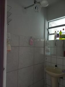 y baño con ducha y lavamanos. en Casa simples em Diamantina, en Diamantina