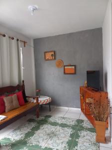 a living room with a couch and a tv at Casa simples em Diamantina in Diamantina