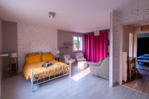 a bedroom with a bed with yellow and orange pillows at La Villa d'Elvine - Maison avec grand jardin in Verrie