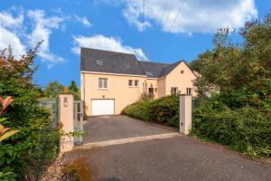 a large white house with a garage at La Villa d'Elvine - Maison avec grand jardin in Verrie