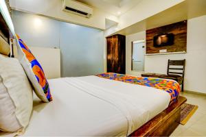 a bedroom with a large white bed and a chair at FabHotel Kwality Inn in Mumbai