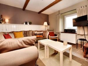 ein Wohnzimmer mit einem Sofa und einem Tisch in der Unterkunft Beautiful holiday home near Vielsalm with rural view in Vielsalm