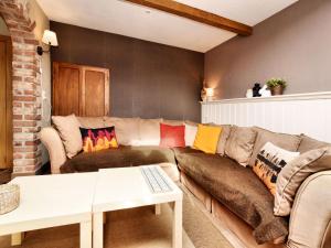 ein Wohnzimmer mit einer Couch mit bunten Kissen darauf in der Unterkunft Beautiful holiday home near Vielsalm with rural view in Vielsalm