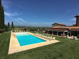 BraccagniにあるResort with pool wellness area and air conditioningの椅子と家のある庭のスイミングプール